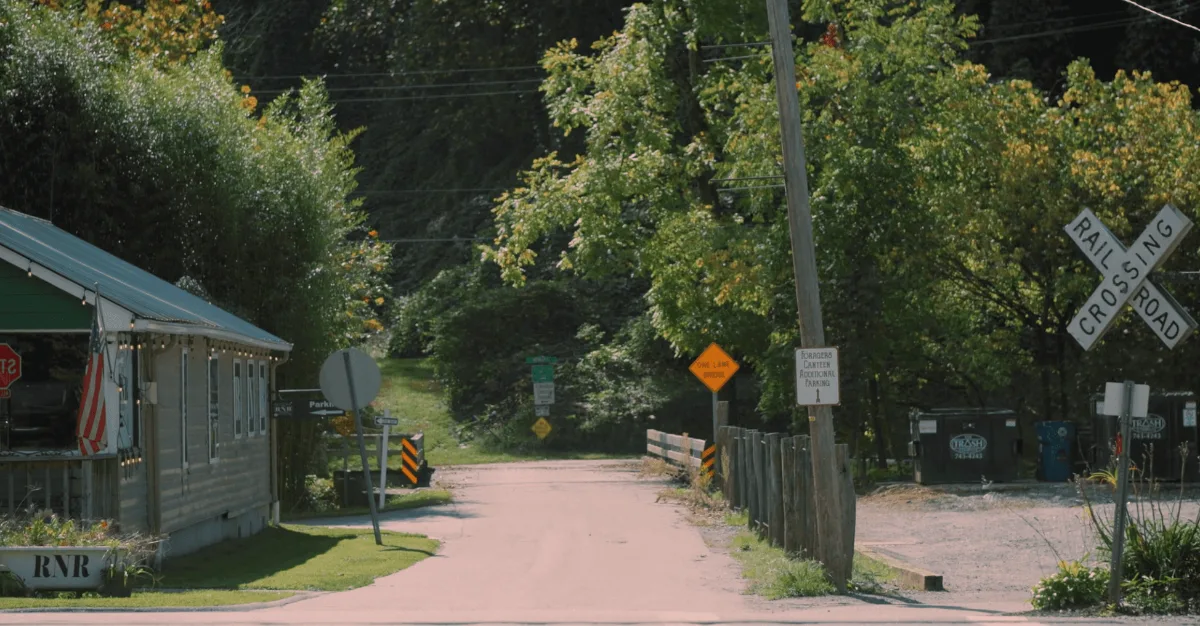 A quiet small-town street beside a railroad crossing.